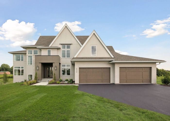 Modern two-story house with three-car garage and green lawn