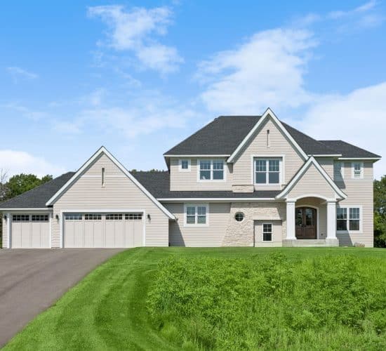 Two-story custom home with stone accents and arched front entry