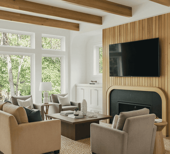 Modern living room with fireplace, TV, wood paneling, and large windows