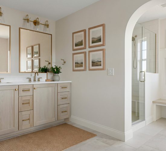 Primary bathroom with light wood double vanity and glass walk-in shower