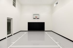 Modern indoor basketball court with hoop and black wall padding
