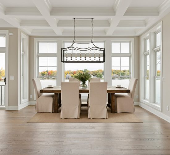 Bright dining room with lake views and coffered ceiling