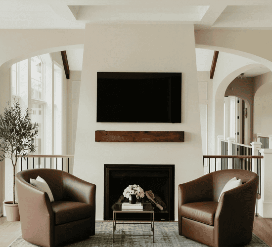 Modern living room with fireplace, TV, and leather chairs
