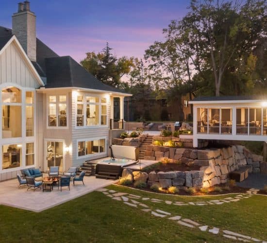 Luxury backyard patio with hot tub, fire pit, and screened porch