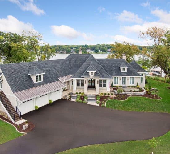 Large lakeside home with landscaped yard and circular driveway