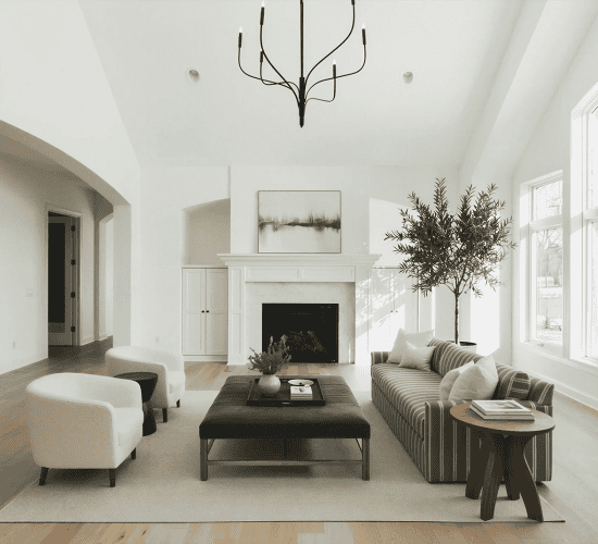 Bright modern living room with fireplace, striped sofa, and arched windows