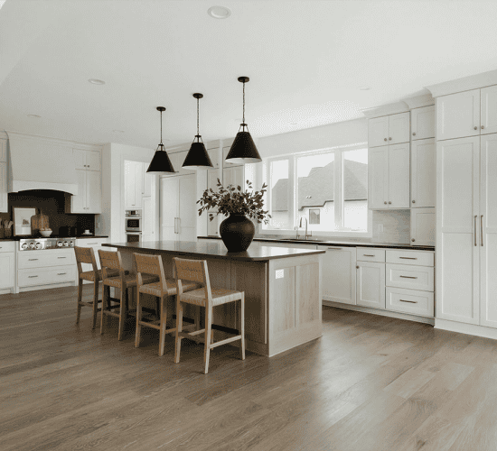 White kitchen with wood island and black pendant lights