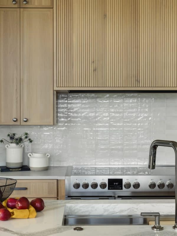 Modern kitchen with wood cabinets, marble island, and stainless stove