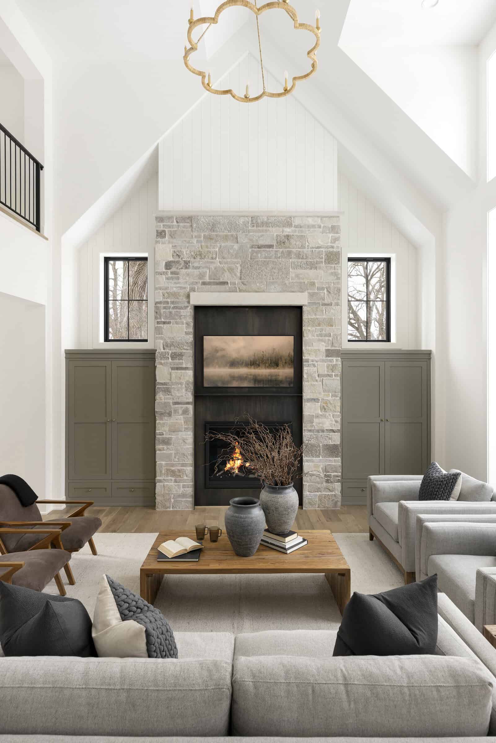 Bright vaulted living room with stone fireplace and modern furnishings