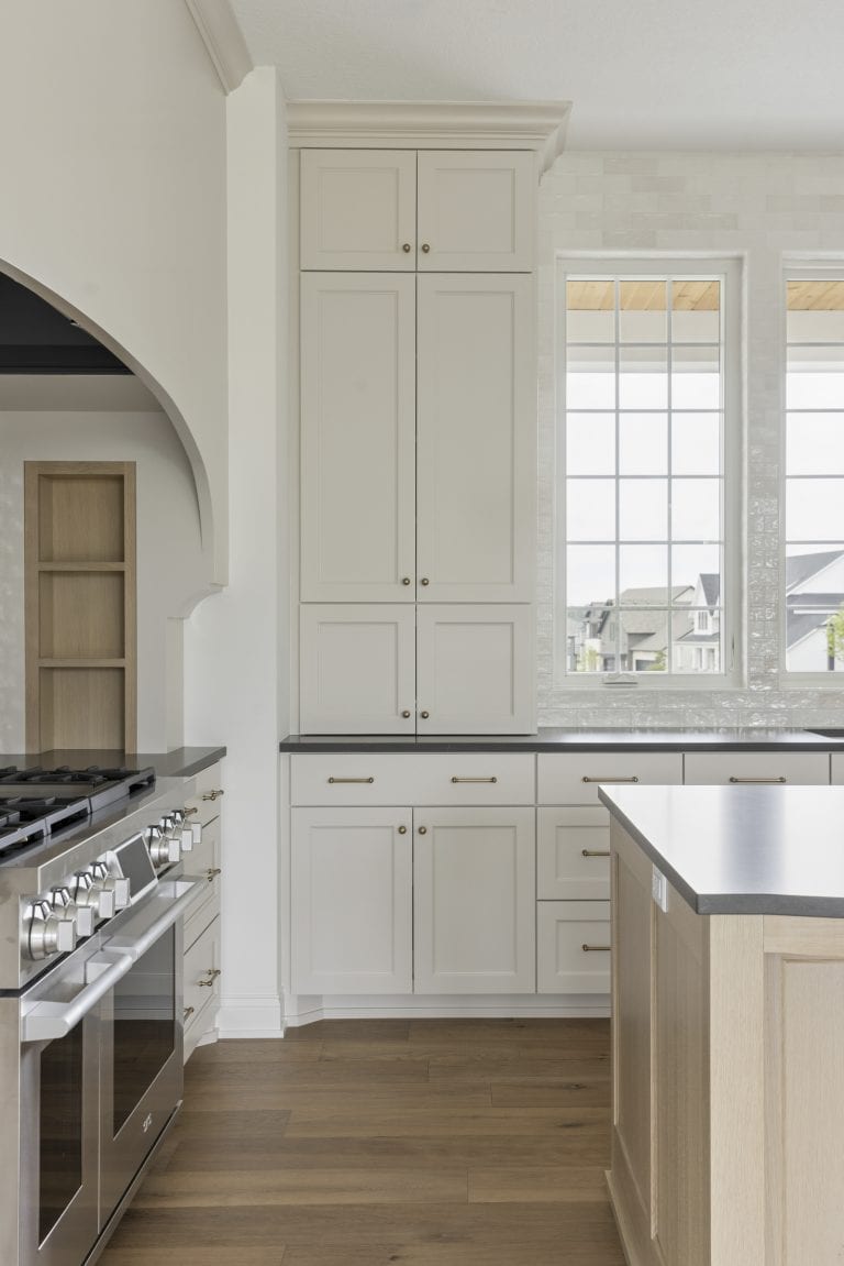 Bright kitchen with gray cabinets, stainless range, and wood island