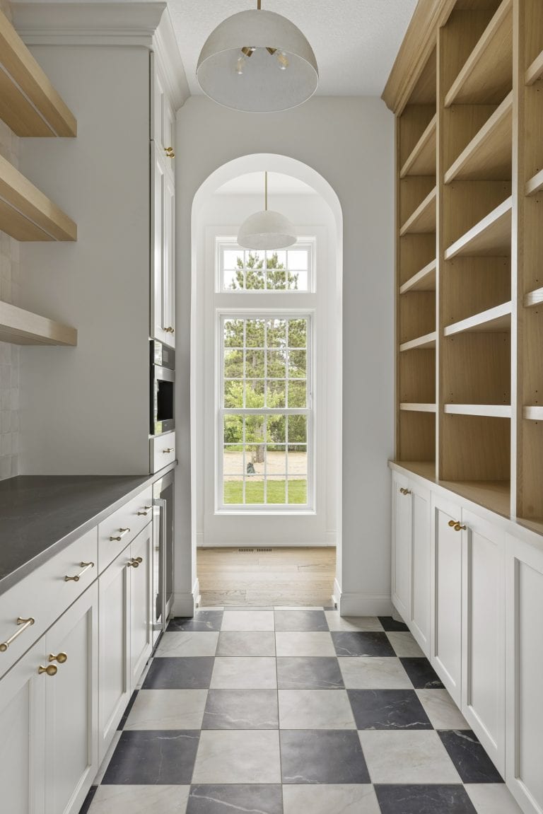 Bright galley kitchen with checkered tile floor and open shelving