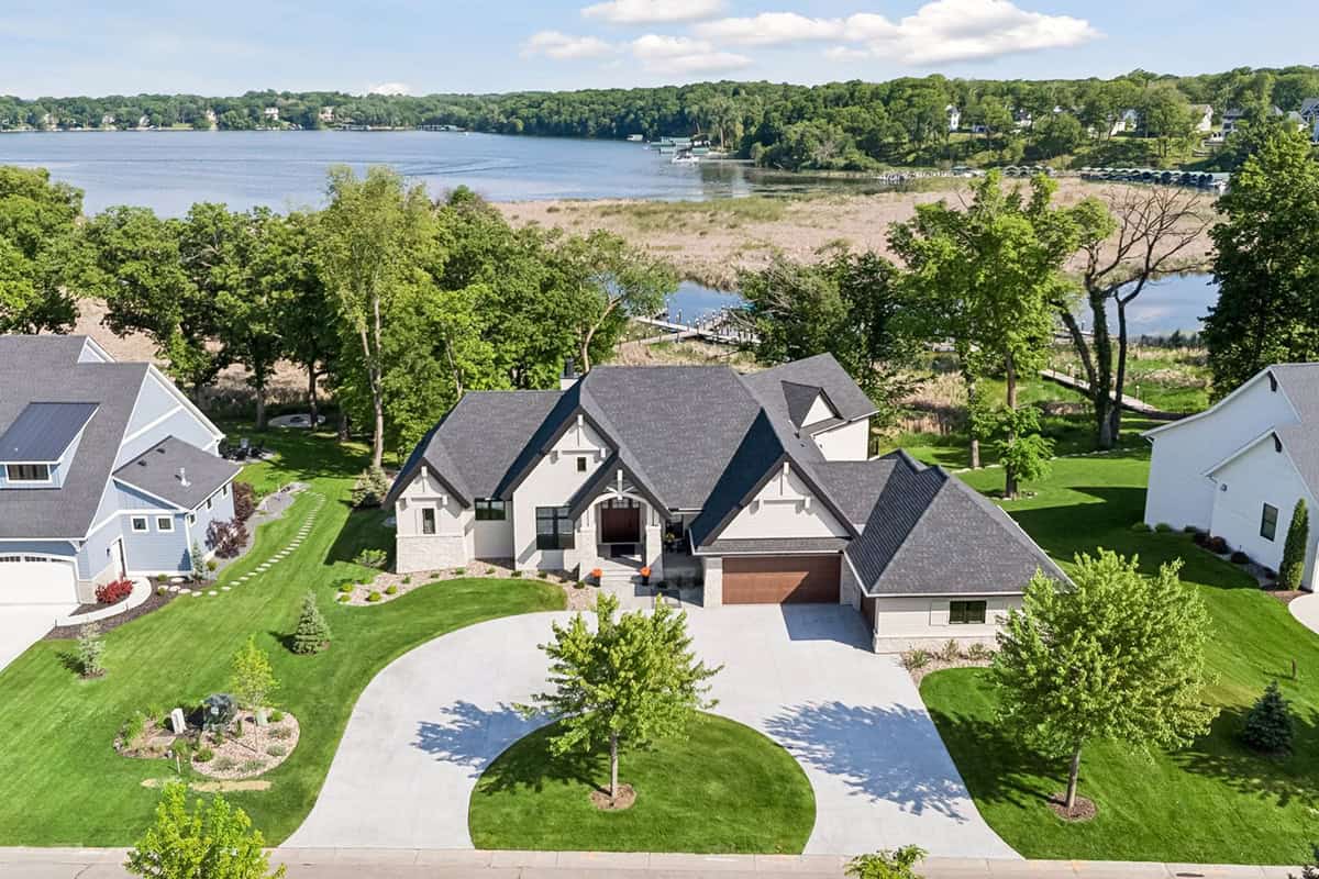 Aerial view of waterfront suburban home with curved driveway