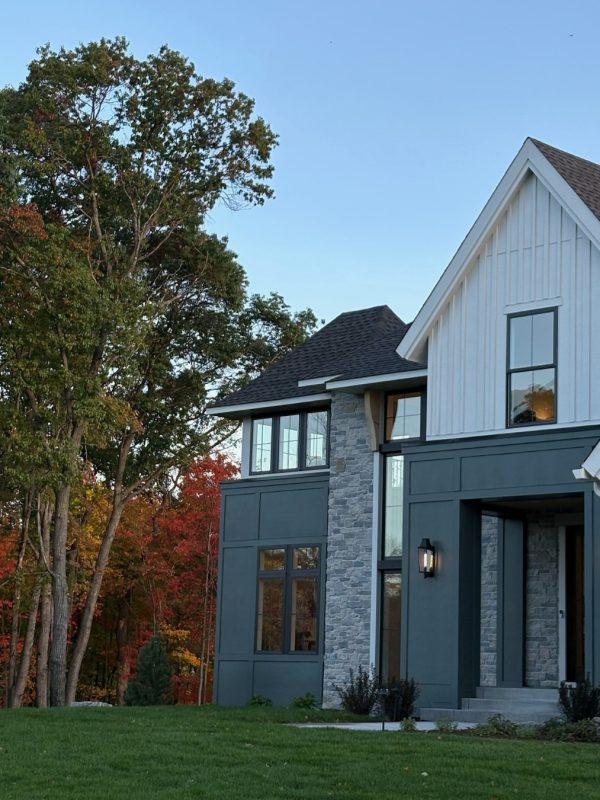 Modern custom home with stone accents and large windows in Elwell Farms.