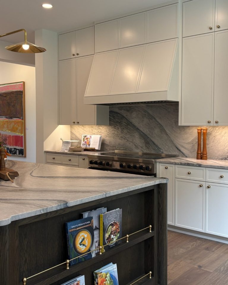 Modern kitchen with white cabinets and marble countertops in a custom home.