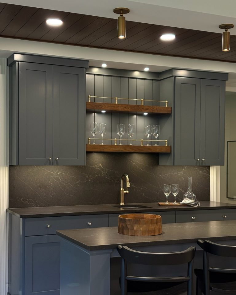 Modern kitchen with blue cabinets, dark countertops, and gold accents.