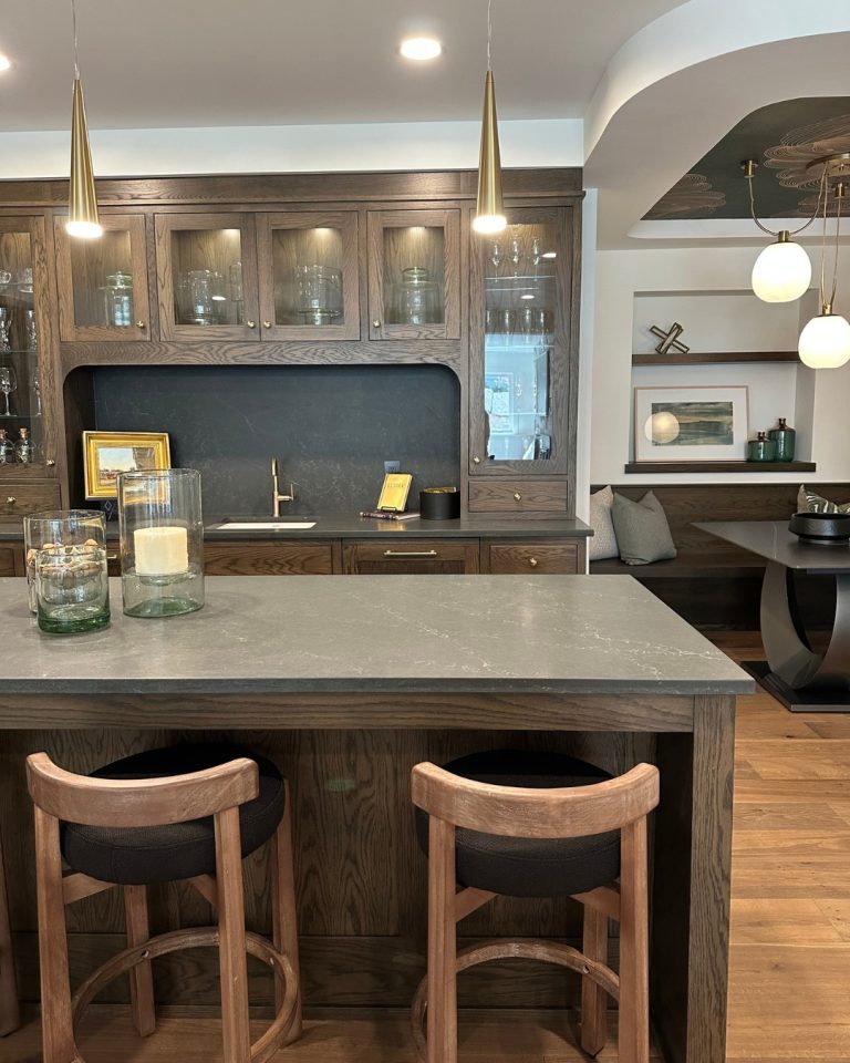 Modern kitchen with dark wood cabinets and a marble island with two stools.