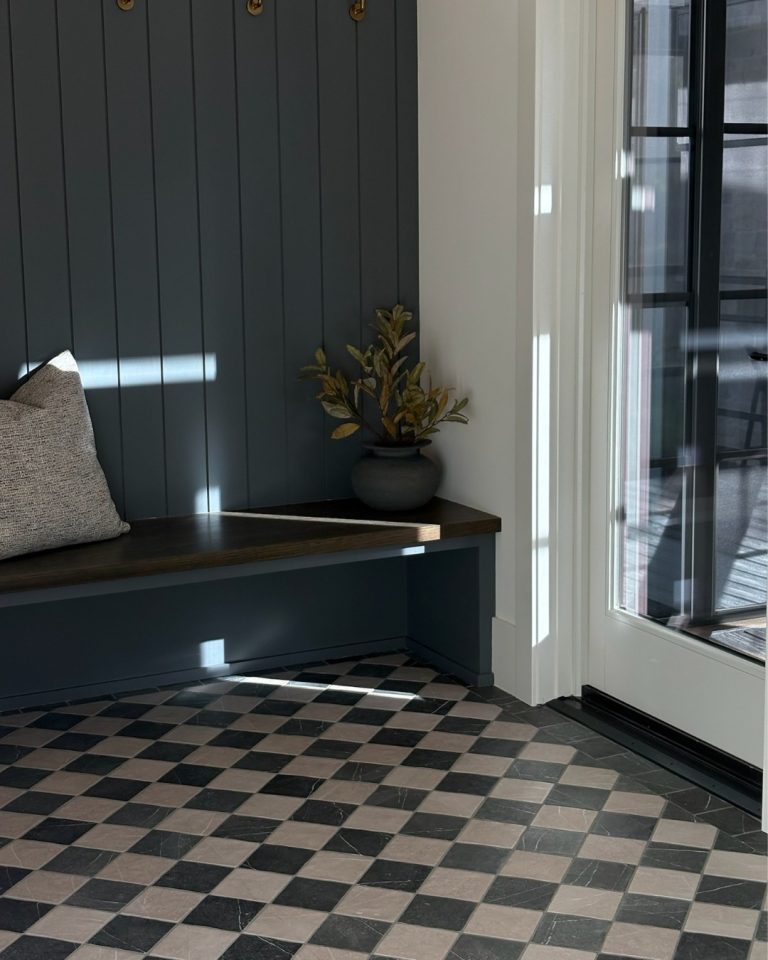 Modern entryway with checkered black and white tile floor and a built-in bench with a cushion.